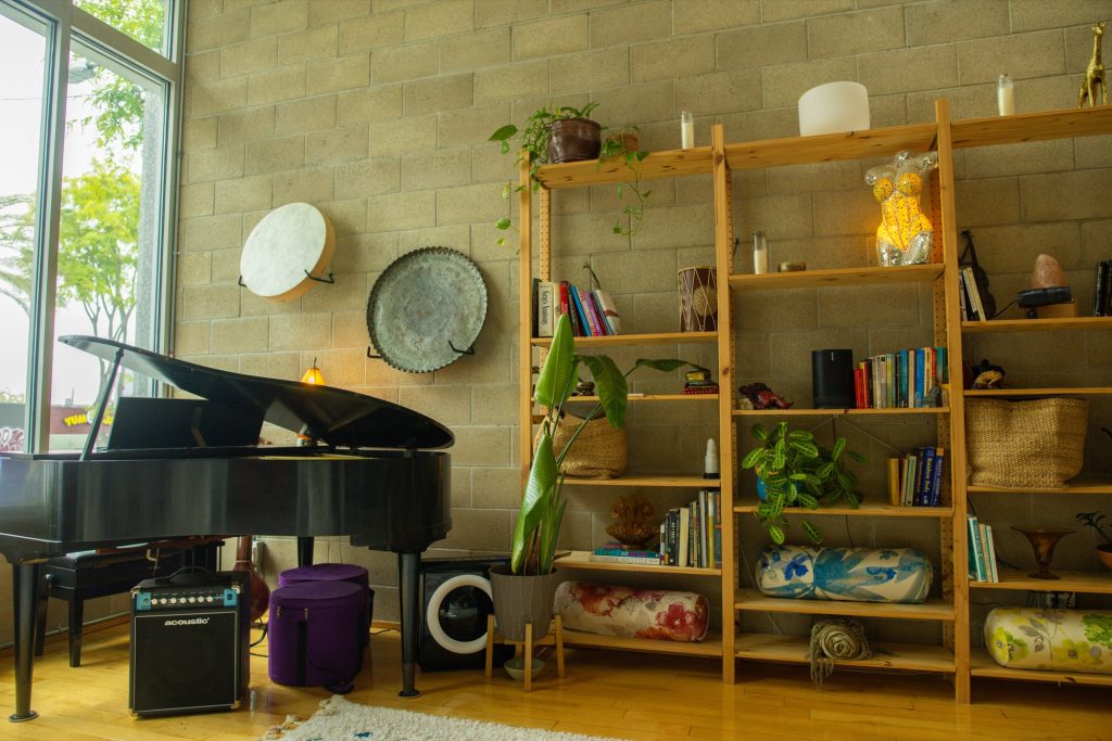 The Word of Mouth Sanctuary in Los Angeles: grand piano, frame drum, and warm shelves of books and plants